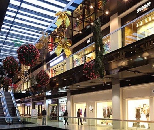 Alışveriş merkezleri, değişen tüketici alışkanlıkları ve hızla dönüşen perakende sektörü ile birlikte her geçen yıl daha yoğun bir rekabet ortamında faaliyet göstermeye devam ediyor. Aynı şehirde faaliyet gösteren farklı AVM projeleri, ziyaretçi sayısını artırabilmek ve tüketicilerin tercih ettiği alışveriş noktası olabilmek için çeşitli yatırımlar gerçekleştiriyor. Mağaza çeşitliliğinden sosyal etkinliklere, dijital hizmetlerden mimari tasarıma kadar birçok unsur, alışveriş merkezleri arasındaki rekabetin temel dinamiklerini oluşturuyor. Konulu bir haber görseli.