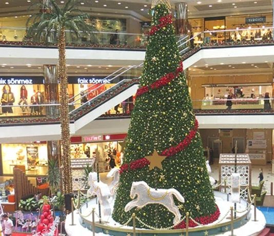 Yılın son haftalarına girilirken alışveriş merkezlerinde hareketlilik gözle görülür şekilde artıyor. Özellikle AVM yönetimleri ve mağazalar, yılbaşı dönemine özel hazırladıkları kampanyalarla hem ziyaretçi sayılarını artırmayı hem de satış performanslarını yükseltmeyi hedefliyor. Giyimden elektroniğe, kozmetikten ev dekorasyonuna kadar birçok kategoride sunulan indirimler, tüketicilerin alışveriş planlarını şekillendirirken alışveriş merkezleri de yılın en yoğun dönemlerinden birini yaşıyor. Konulu bir haber görseli.