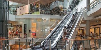 Alışveriş merkezleri son yıllarda yalnızca alışveriş yapılan yapılar olmanın ötesine geçerek sosyal yaşamın önemli merkezlerinden biri haline geliyor. Değişen tüketici beklentileri doğrultusunda geliştirilen AVM’lerde sosyal alanlar, ziyaretçilerin daha uzun süre vakit geçirmesini sağlayan ve farklı yaş gruplarına hitap eden yaşam alanları olarak dikkat çekiyor. Kafeler, dinlenme alanları, çocuk oyun merkezleri, etkinlik sahaları ve açık hava bölümleri gibi birçok sosyal alan, yeni nesil alışveriş merkezlerinin vazgeçilmez unsurları arasında yer alıyor. Konulu bir haber görseli.